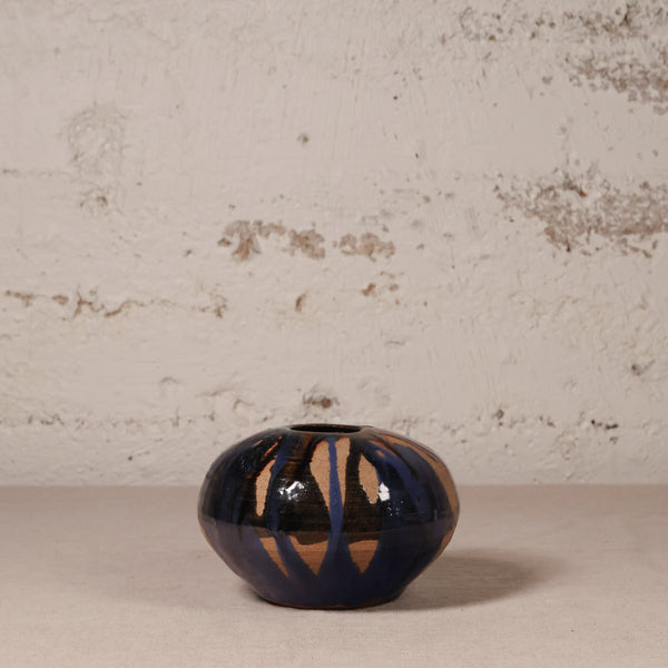 Ceramic vase with abstract design on a textured surface