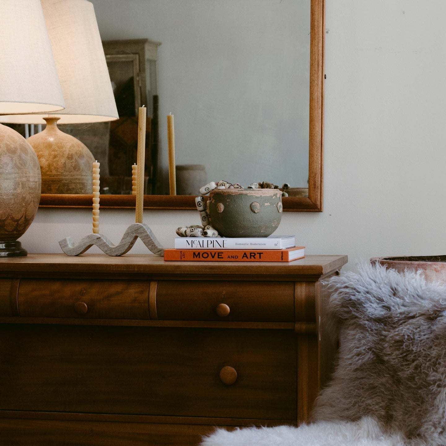 dresser with lamps and art books