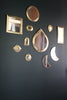 Moroccan Brass Mirrors - variety of shapes on a black wall 