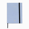 Light blue notebook with a black strap on a white background
