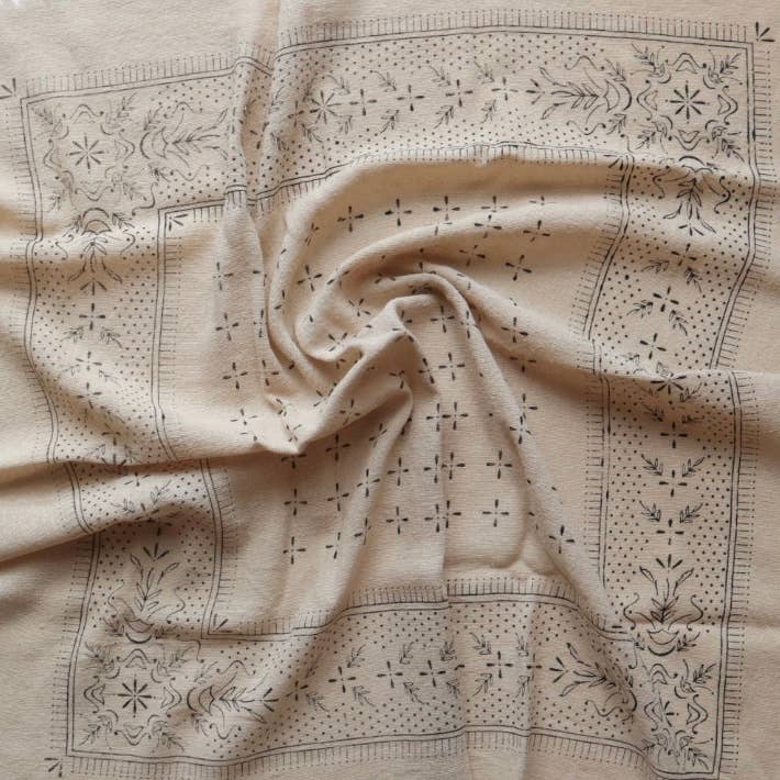 Beige fabric with intricate black embroidery patterns