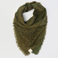 Green patterned scarf on a light gray background