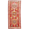 Handwoven Turkish wool rug featuring bold pink and red patterns with orange and sage accents.