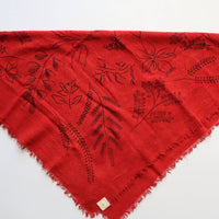 Red scarf with black floral patterns on a white background