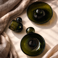 Green glass bowls on a beige fabric surface