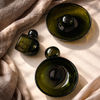 Green glass bowls on a beige fabric surface