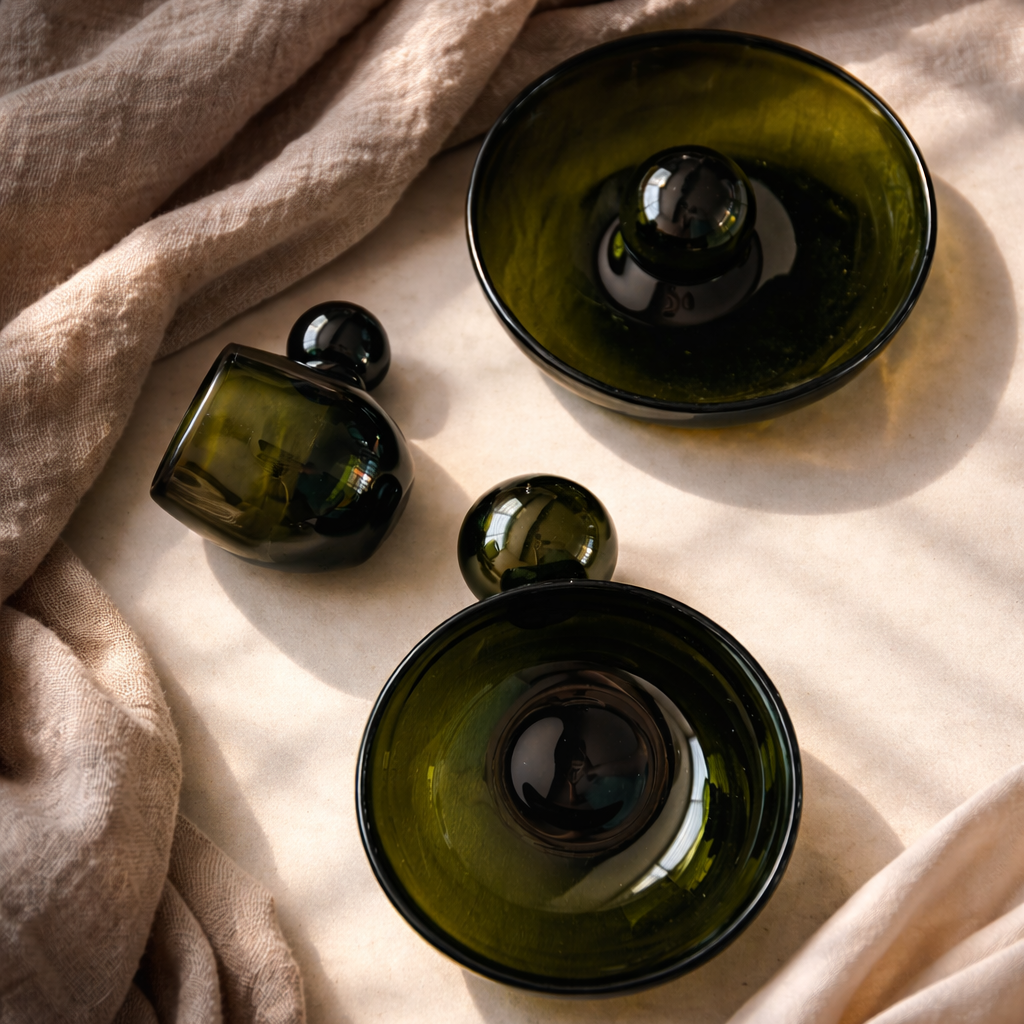 Green glass bowls on a beige fabric surface