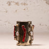A vintage-style silver-toned cuff bracelet decorated with red enamel inlays, white pearl-like beads, and small silver studs, set against a textured off-white background.
