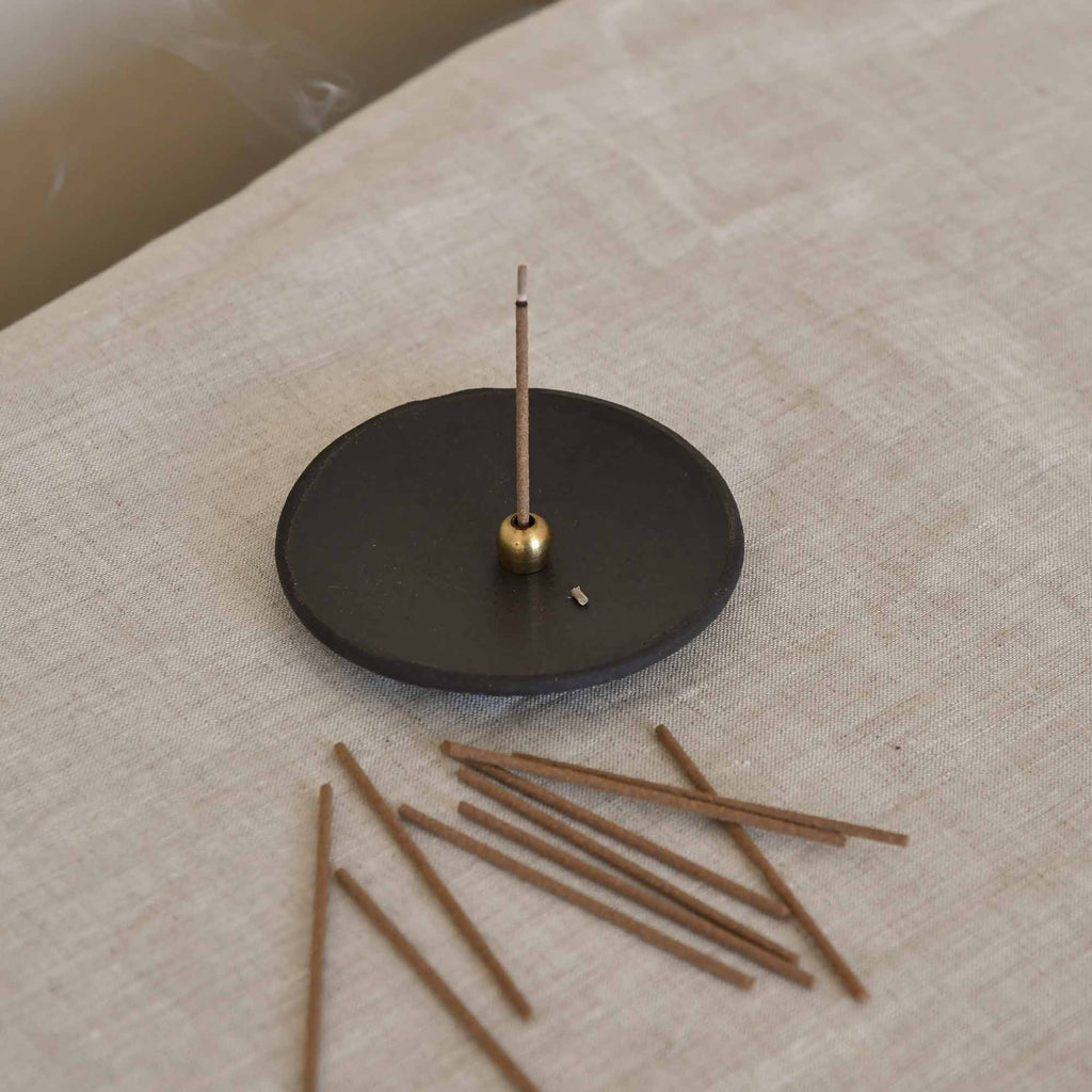 Rose Floral Japanese Incense Sticks displayed on a table and one being burned 