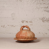 Ceramic container with lid on a textured surface
