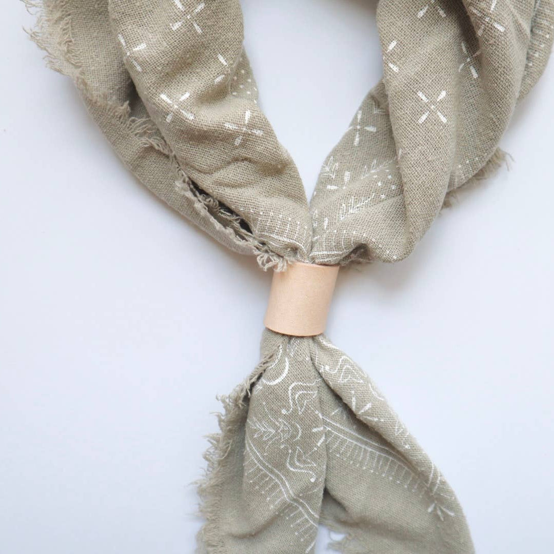Beige scarf with subtle patterns on a white background