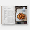Open book showing a recipe for arancini with a photograph of a dish on a table.