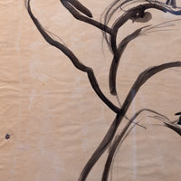 A close-up of a traditional ink painting on textured beige paper, showing dark black brushstrokes of branches or leaves.