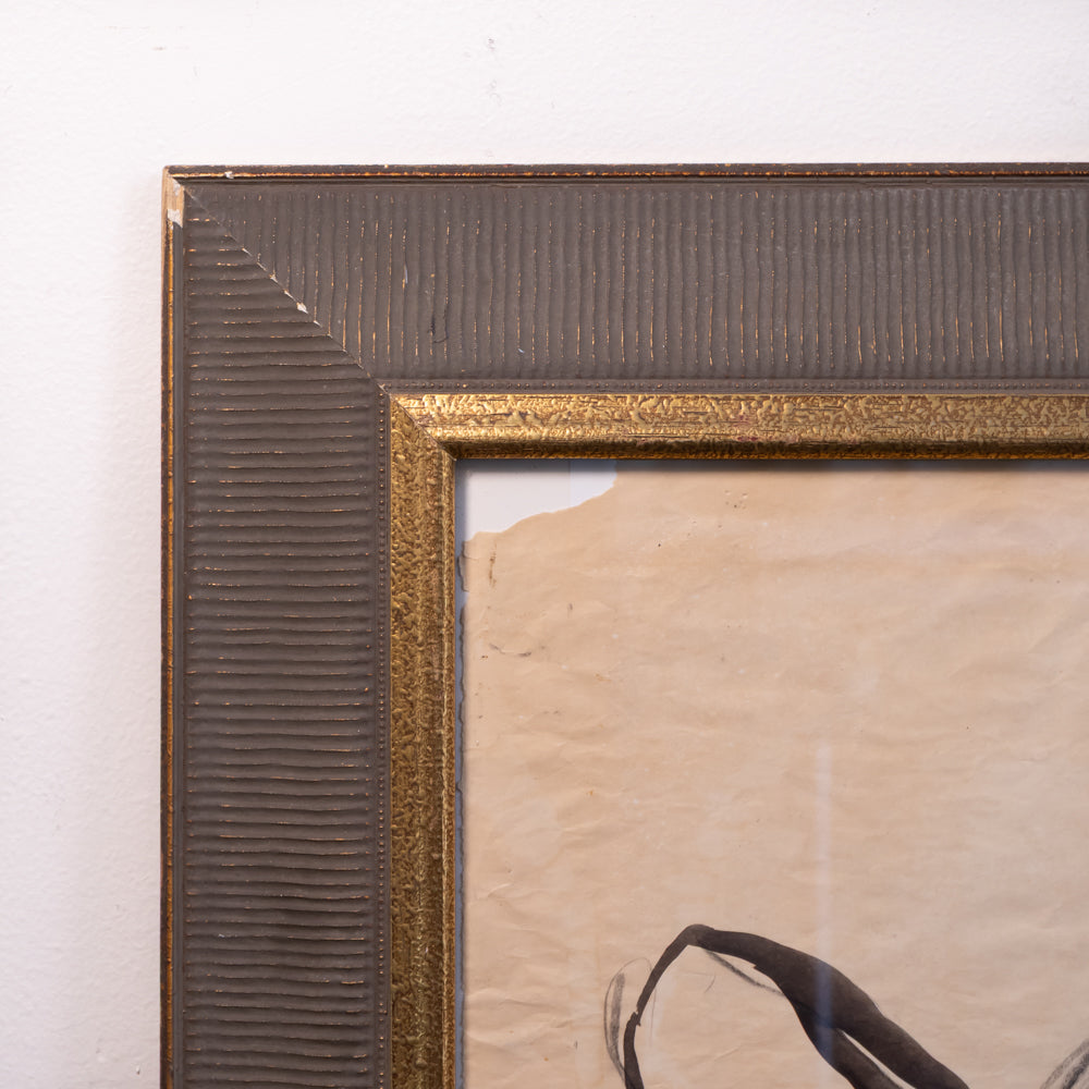 Close-up of a framed artwork corner showing a textured dark brown frame with a gold inner border and a beige paper background.