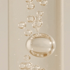 Close-up of clear gel-like substance with bubbles on a beige background