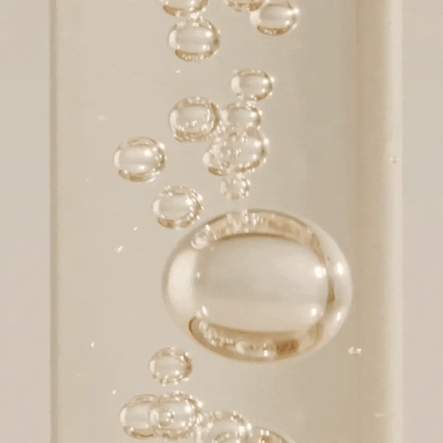 Close-up of clear gel-like substance with bubbles on a beige background
