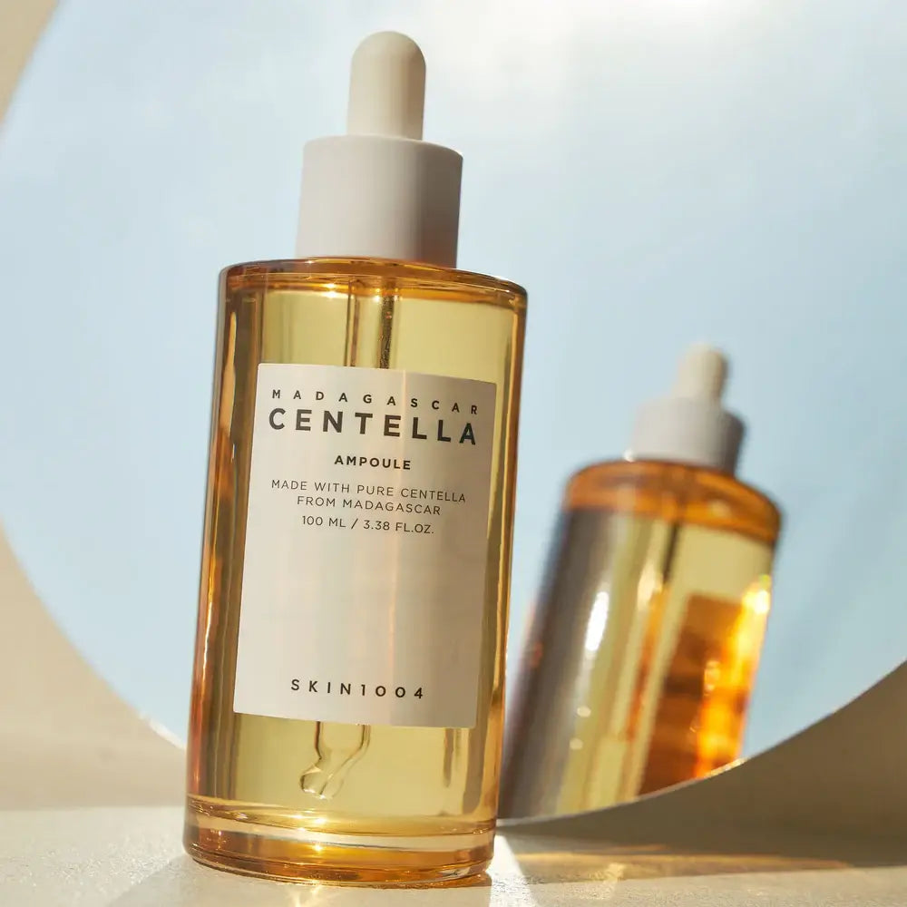 Skincare bottle labeled 'Madagascar Centella Ampoule' with a dropper on a light blue background.