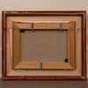 The back view of a framed canvas painting, showing the wooden frame, canvas fabric backing, and hanging hardware against a textured off-white wall.