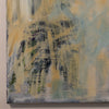 An abstract canvas painting featuring textured brushstrokes of muted yellow, pale blue, gray, and dark charcoal gray, shown hanging on a light beige wall.
