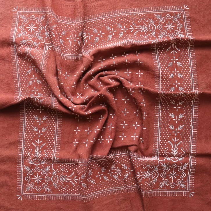 Brown fabric with white floral patterns, possibly a scarf or towel.