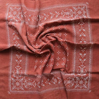 Brown fabric with white floral patterns, possibly a scarf or towel.