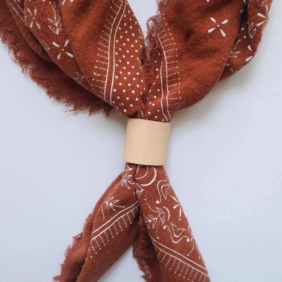 Brown bandana with white patterns on a light gray background