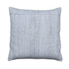 A square throw pillow in a textured light gray linen-like fabric, displayed flat on a rustic gray wooden plank surface.