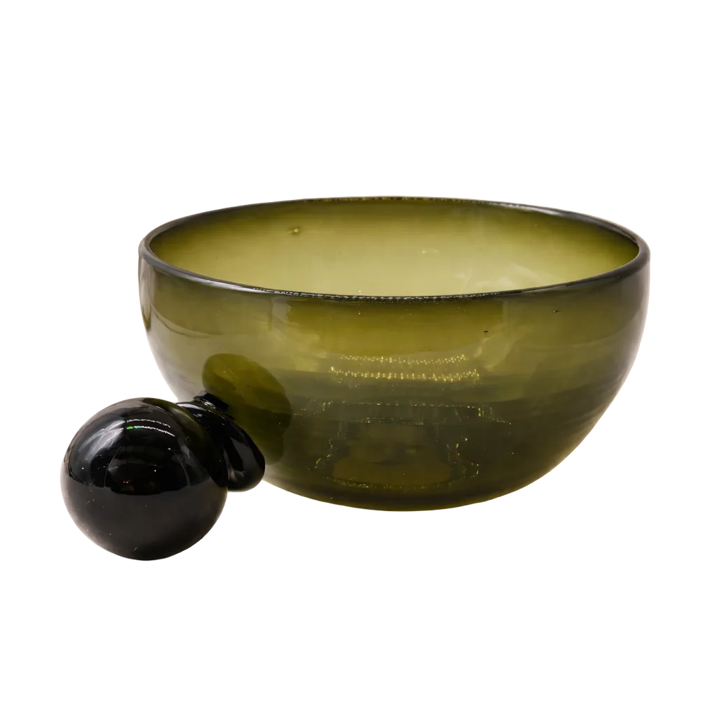 Green glass bowl with black handle on a light background