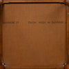 The back of a wooden framed picture or mirror, showing a brown textured backing board with metal corner brackets and printed text reading 'DENMARK 77' and 'TRIOH MADE IN DENMARK 77'.