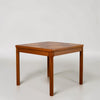 A square wooden side table with a geometric inlaid top and four straight legs, photographed against a plain light gray studio background.