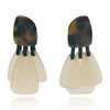Pair of earrings with tortoiseshell top and beige bottom on a white background