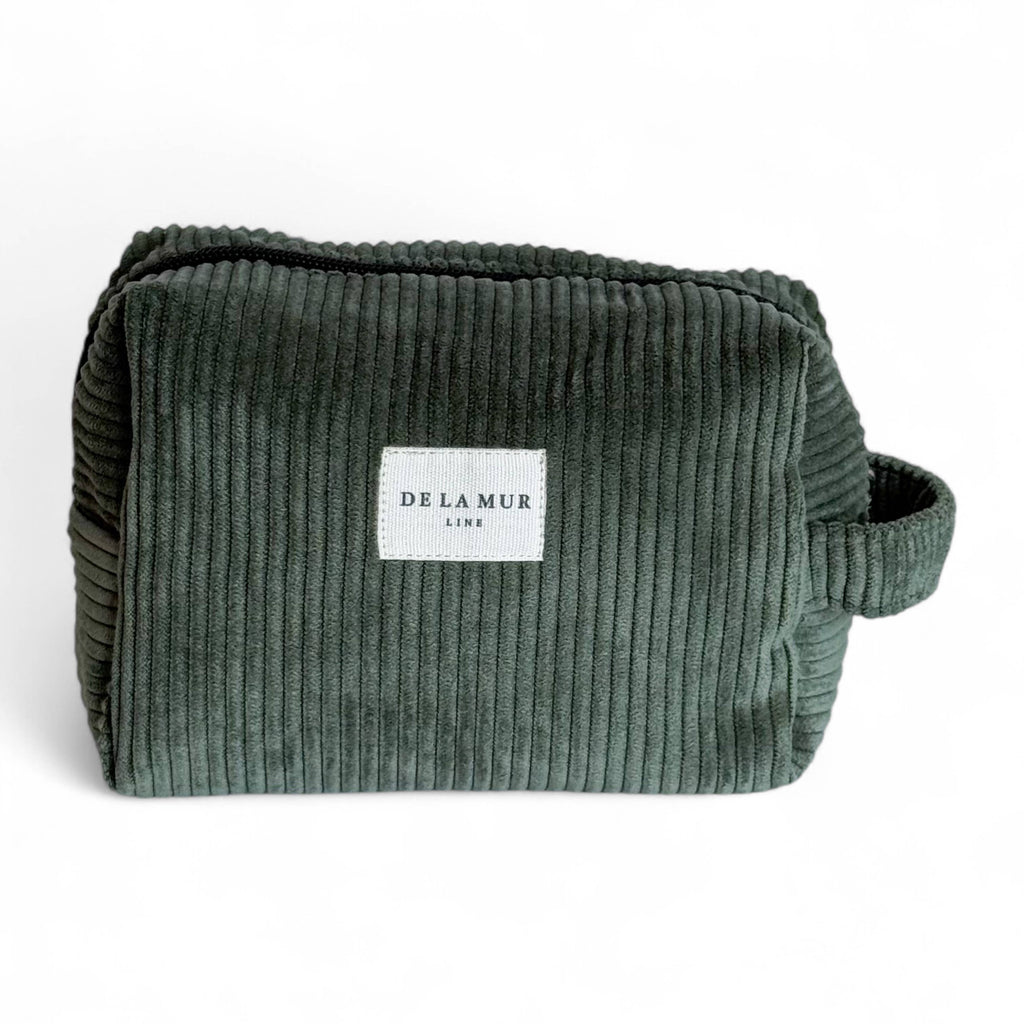 Green corduroy pouch with a visible brand label on a white background