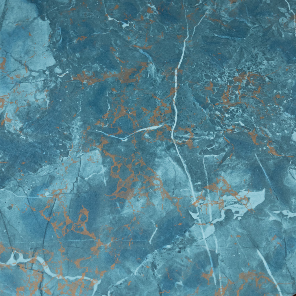 A close-up of a blue marble-like surface with white veining and scattered metallic copper-orange flecks.