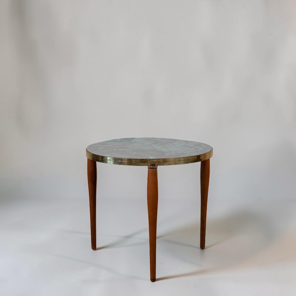 A round side table with a gray stone top, a brass rim, and three tapered brown wooden legs, photographed against a neutral light gray background.