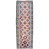 A long rectangular tribal-style runner rug with a geometric diamond pattern in red, navy, cream, and light blue, bordered on the sides with repeating star motifs.