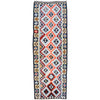 A long rectangular tribal-style runner rug with a geometric diamond pattern in red, navy, cream, and light blue, bordered on the sides with repeating star motifs.