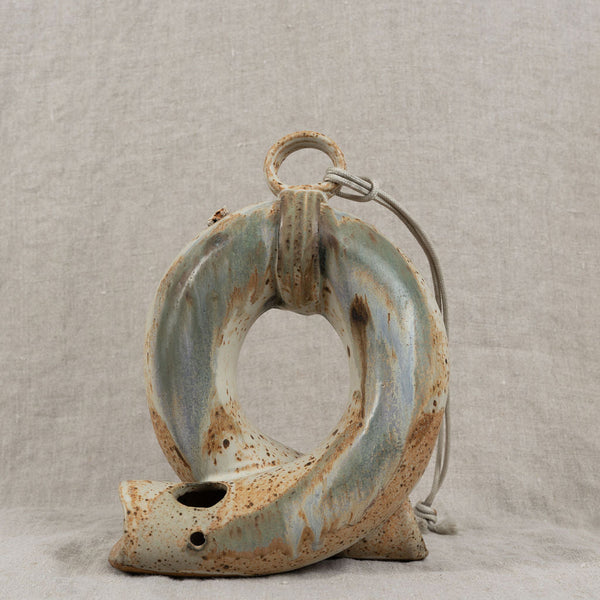 Ceramic wall hook with rustic finish on a textured gray background