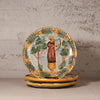 A stack of hand-painted ceramic plates with a rustic Mediterranean style, featuring a central figure playing a harp surrounded by trees and a border of lemons, displayed on a neutral surface against a textured plaster wall.