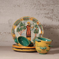 Set of ceramic dishes with artistic designs on a textured surface