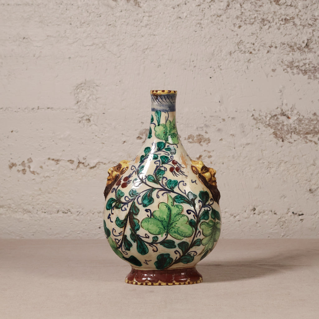 Decorative ceramic vase with green leaf patterns on a textured surface