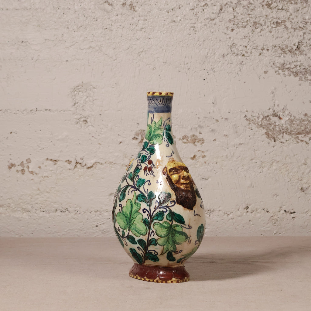 Decorative ceramic vase with floral patterns on a textured wall background