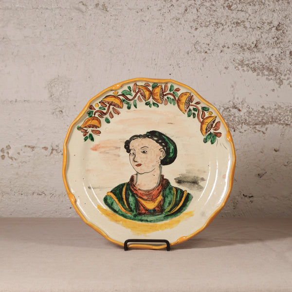Ceramic plate with a decorative border and central portrait on a textured surface