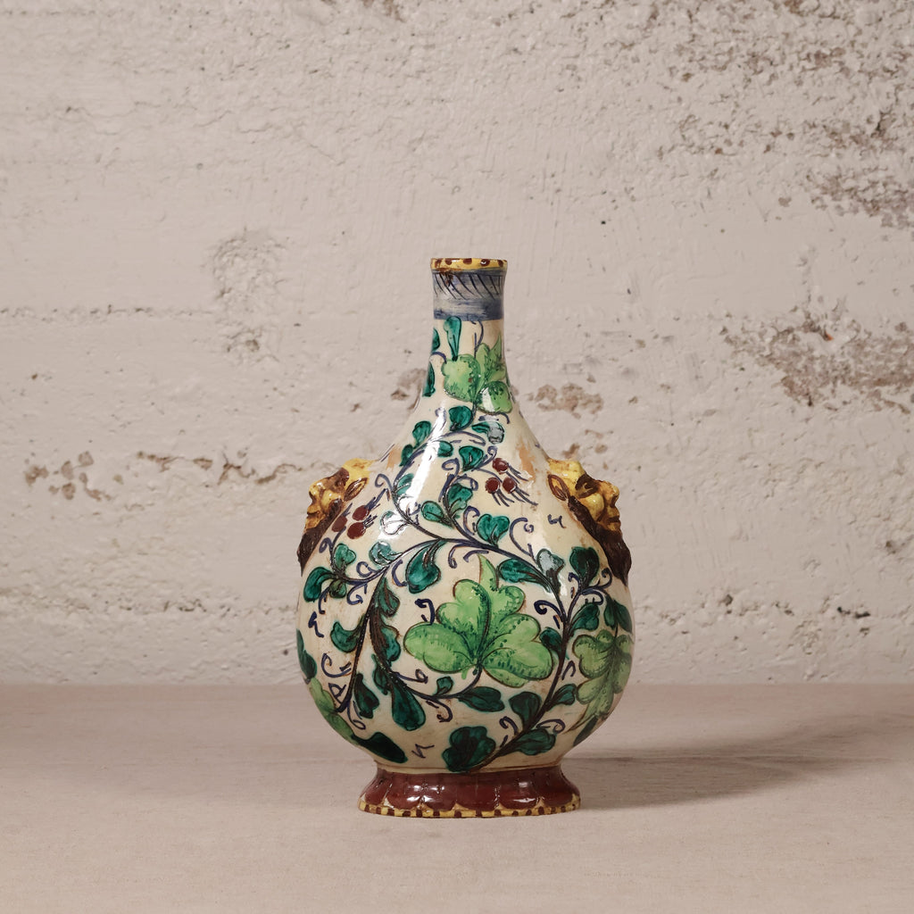 Decorative ceramic vase with green leaf patterns on a textured surface