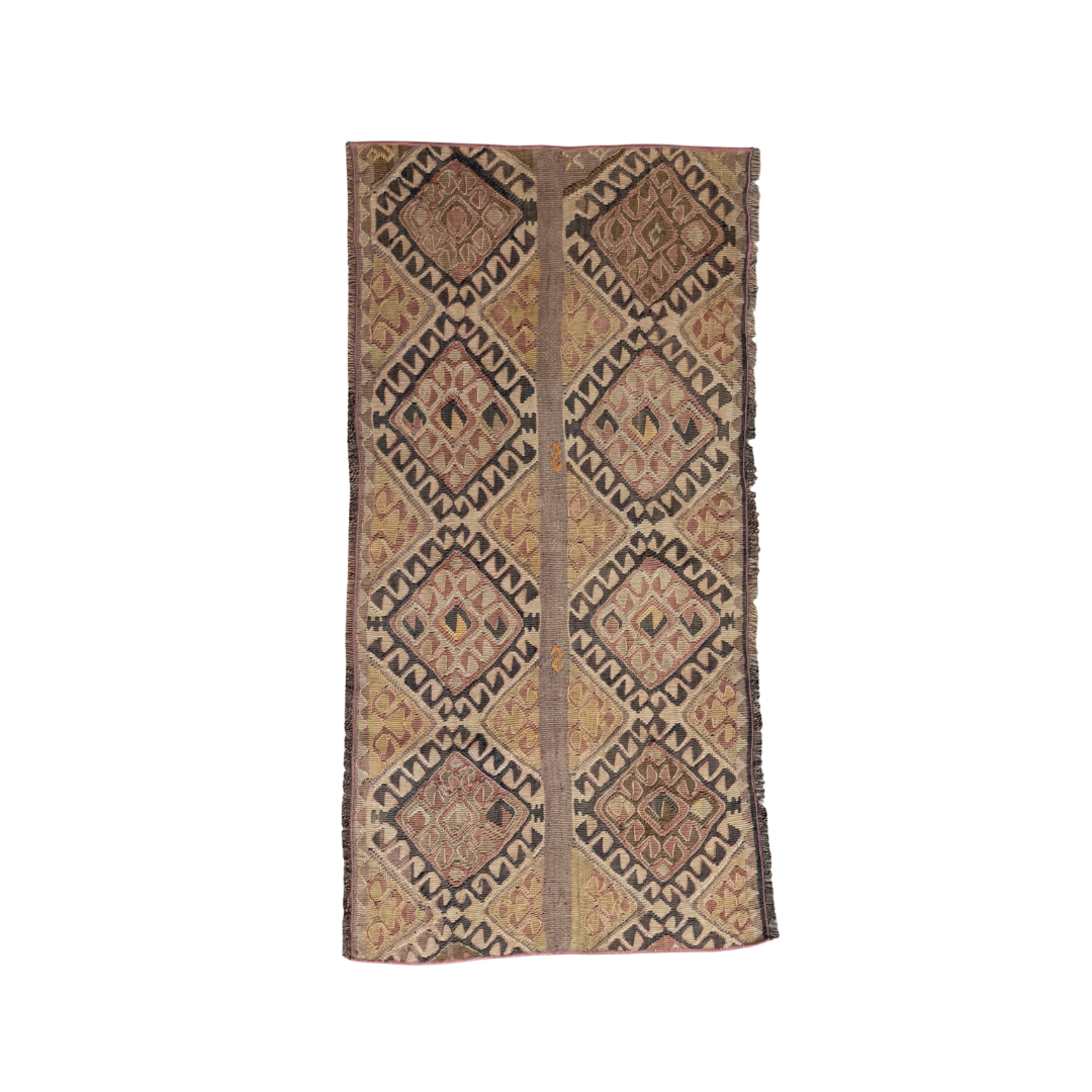 A rectangular hand-woven area rug with a geometric diamond pattern in shades of brown, beige, and muted orange, shown flat against a solid white background.
