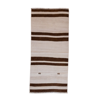 A rectangular woven rug with horizontal stripes in dark brown and cream, featuring small decorative motifs near the bottom center and fringed edges.