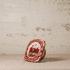 Decorative ceramic piece with intricate design on a textured surface