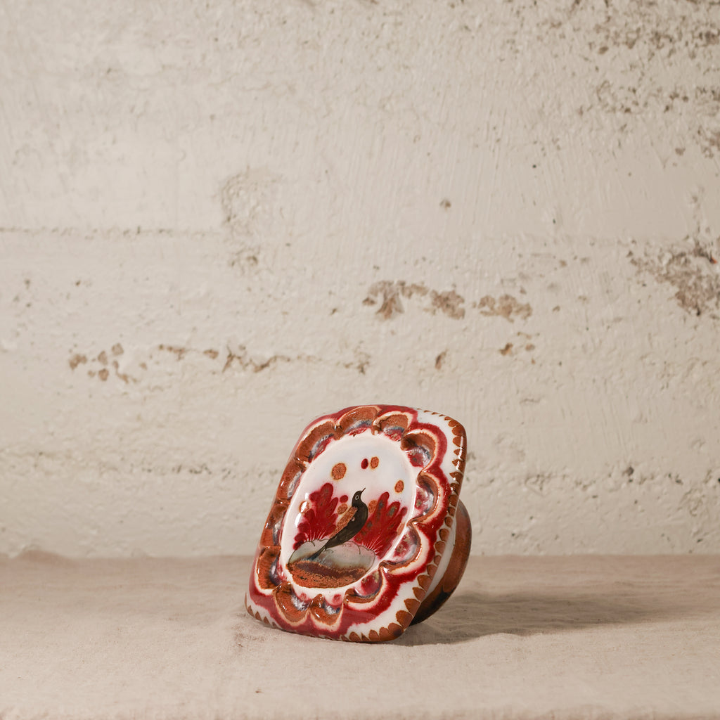 Decorative ceramic piece with intricate design on a textured surface