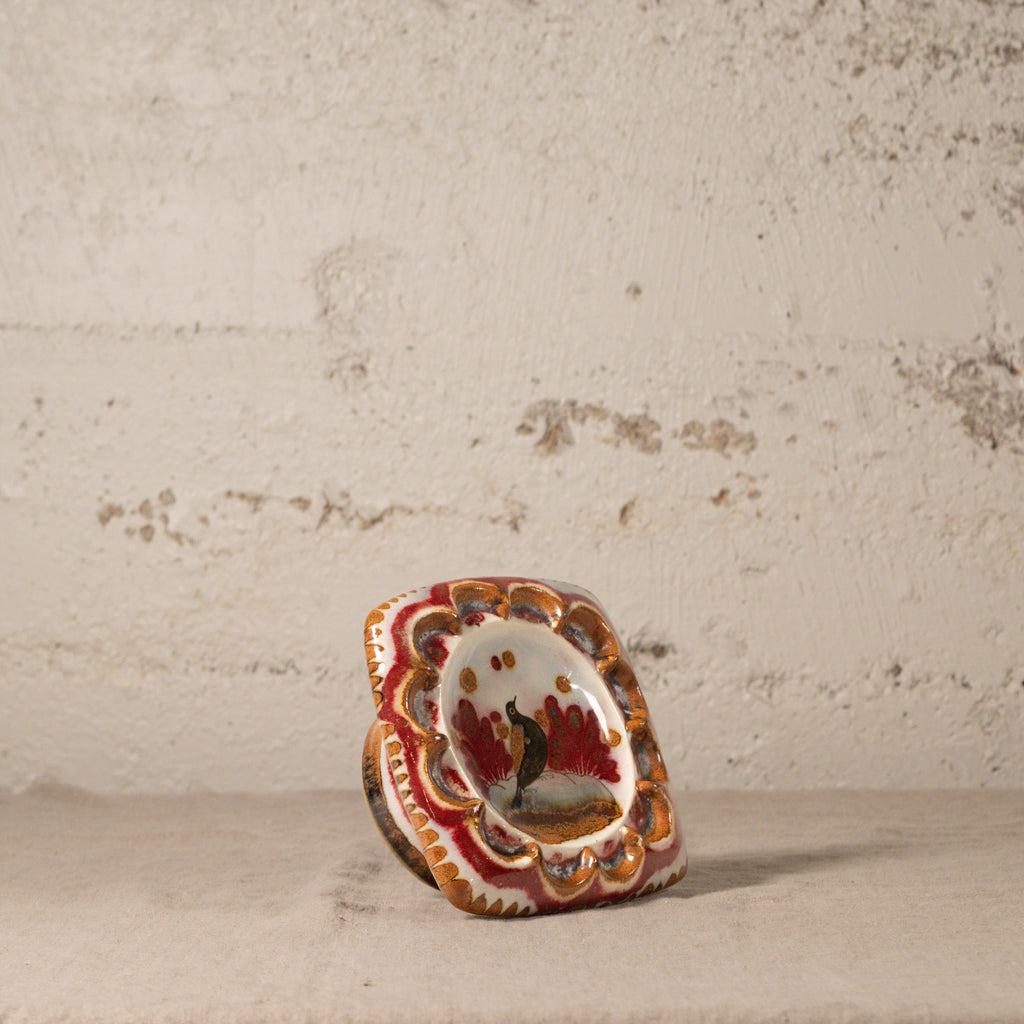 Small ceramic piece with decorative design on a textured surface