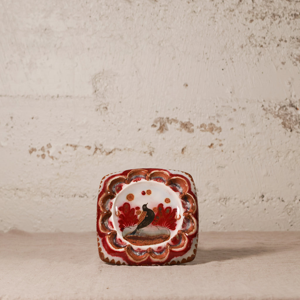 Decorative ceramic square ashtray with a bird design on a textured surface
