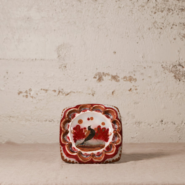 Decorative ceramic square ashtray with a bird design on a textured surface